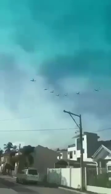 Two Philippine Air Force planes flying in formation above a residential area before colliding.