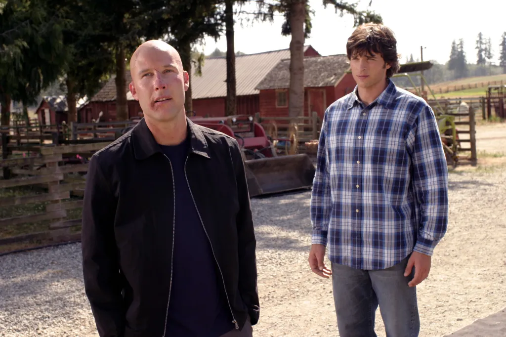Michael Rosenbaum as Lex Luthor and Tom Welling as Clark Kent standing outdoors on a farm in Smallville.
