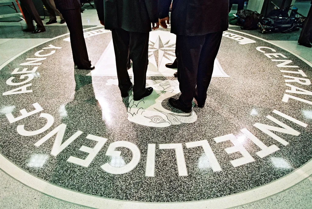 President George W. Bush, Central Intelligence Agency Director George Tenet and others stand on the seal of the agency at the CIA Headquarters in Langley, Virginia.