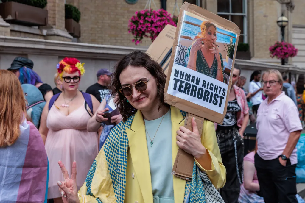 A participant at the London Trans+ Pride march holds a sign criticizing author J.K. Rowling.