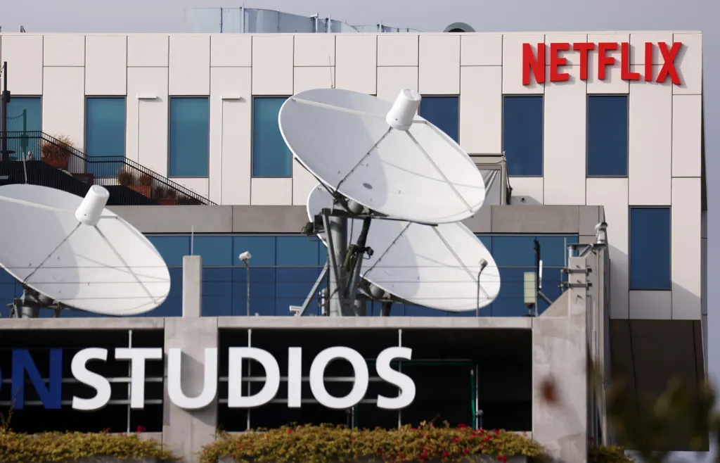 The Netflix logo displayed on the exterior of the company's Los Angeles headquarters, with satellite dishes in the foreground.
