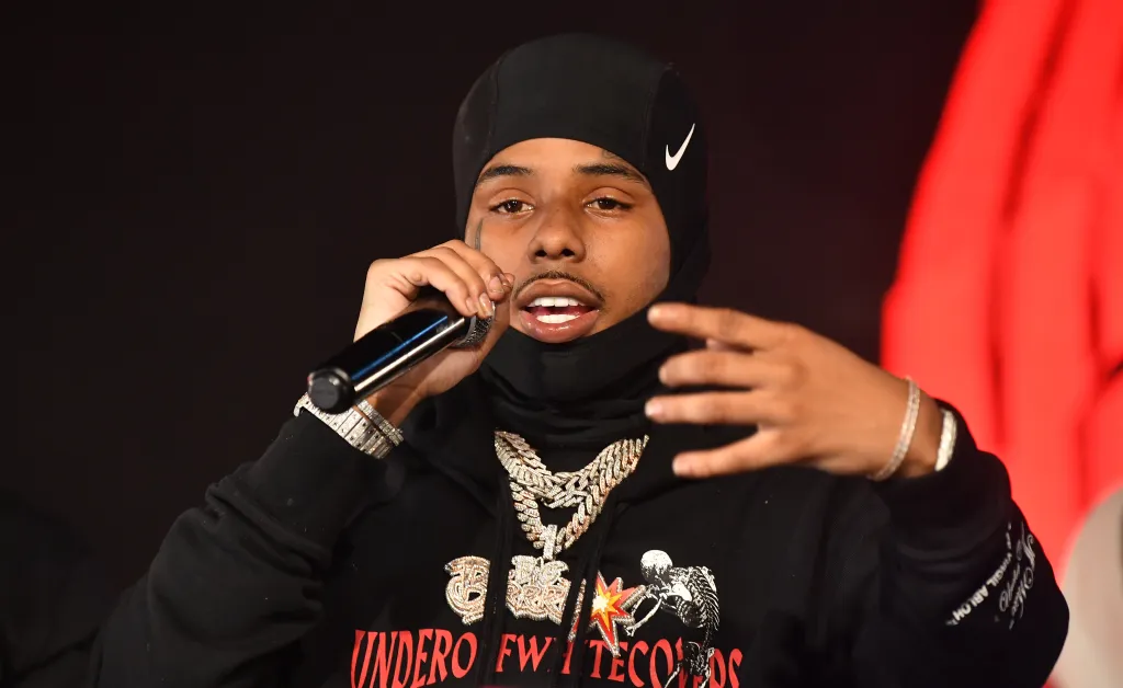 Rapper Pooh Shiesty performs onstage wearing a black ski mask and chains.