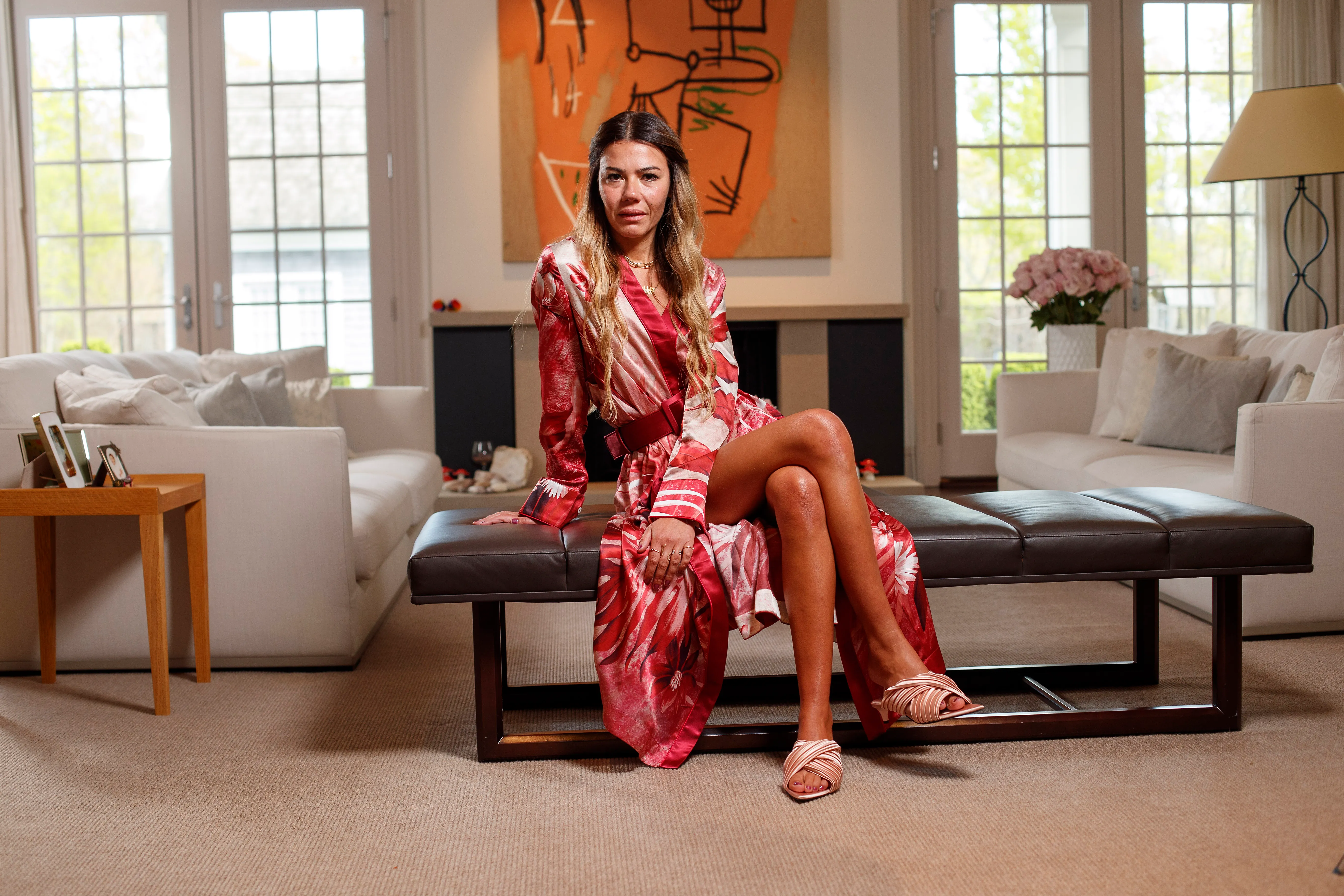 Libbie Mugrabi sitting on a bench inside her home.