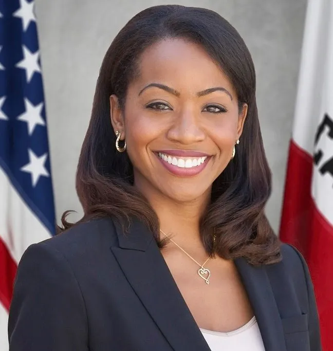 Portrait of Malia M. Cohen smiling, with American and California state flags in the background.
