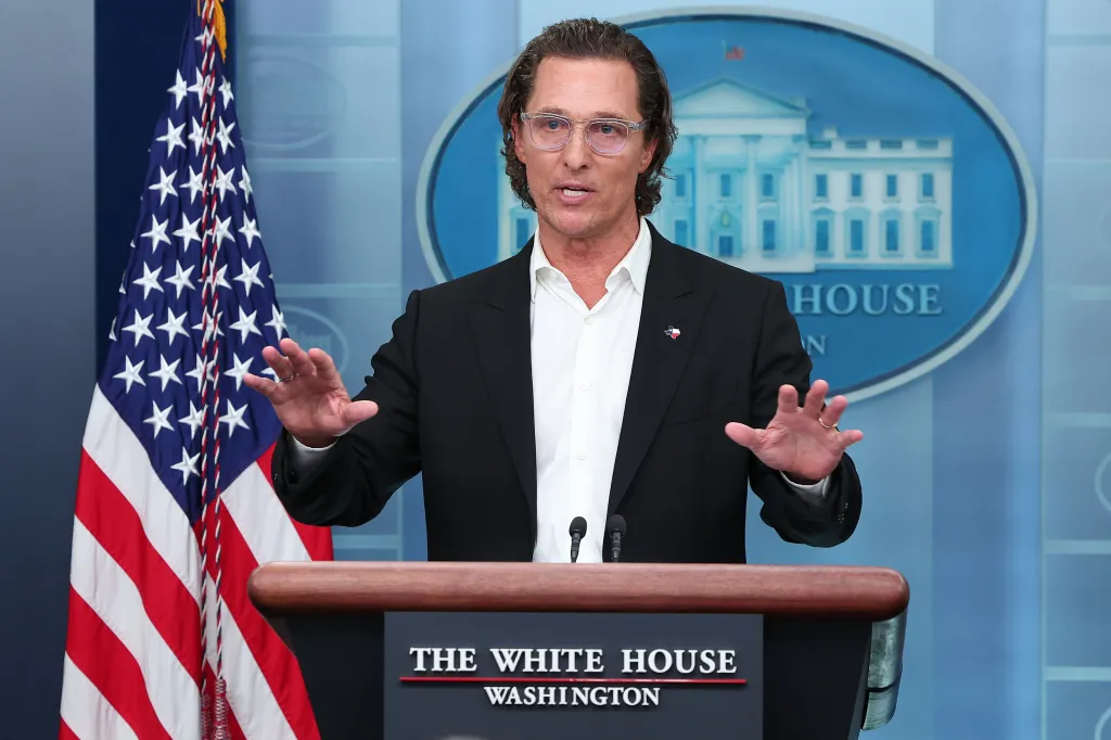 Actor Matthew McConaughey speaks at the White House press briefing podium, gesturing with his hands.
