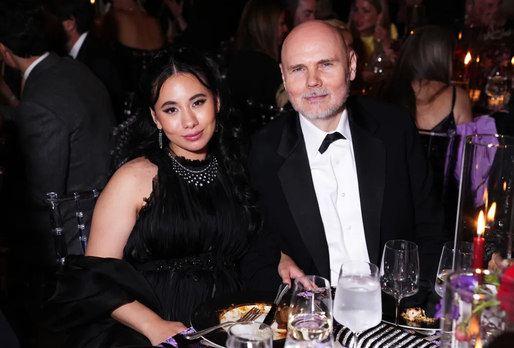 Chloe Mendel Corgan and Billy Corgan seated at a table during a gala.