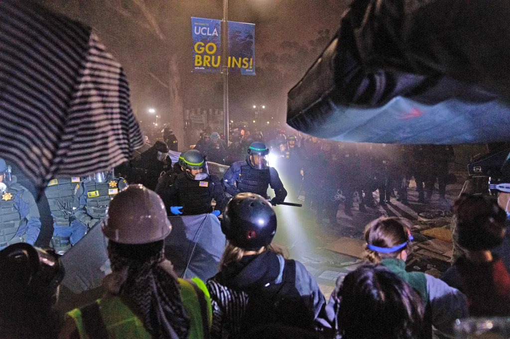 Pro-Palestinian protesters face off against law enforcement in riot gear during an encampment raid at UCLA.