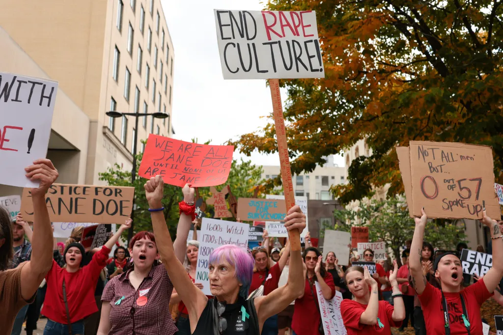 Protesters hold signs demanding accountability at a rally supporting a former Cornell University student.