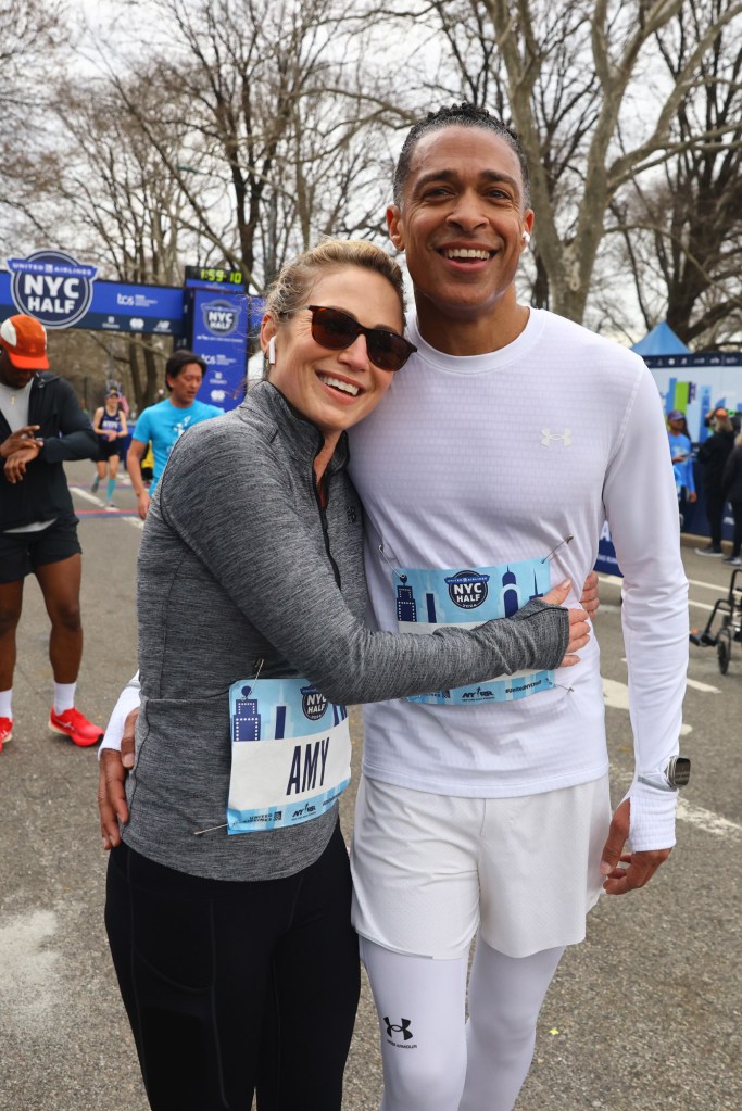 Amy Robach and T.J. Holmes smiling and embracing at the NYC Half Marathon.