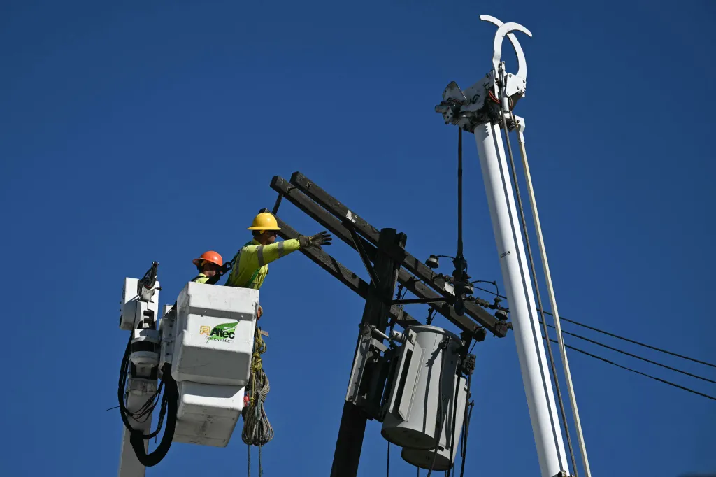 Los Angeles Department of Water and Power (LADWP) employees repair a power pole damaged during the Palisades Fire.