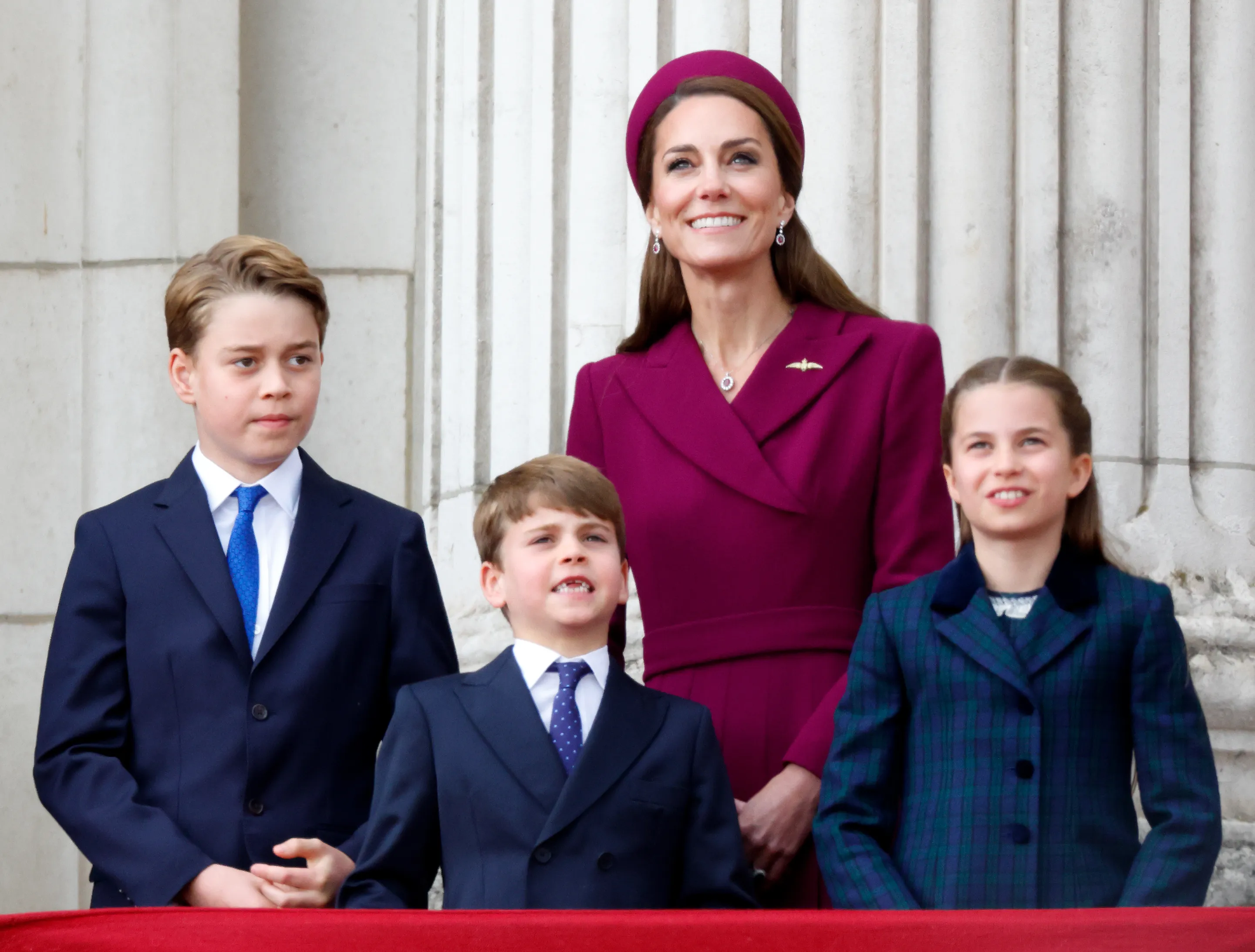 Catherine, Princess of Wales, stands on a balcony with Prince George, Prince Louis, and Princess Charlotte during commemorations for the 80th anniversary of VE Day.