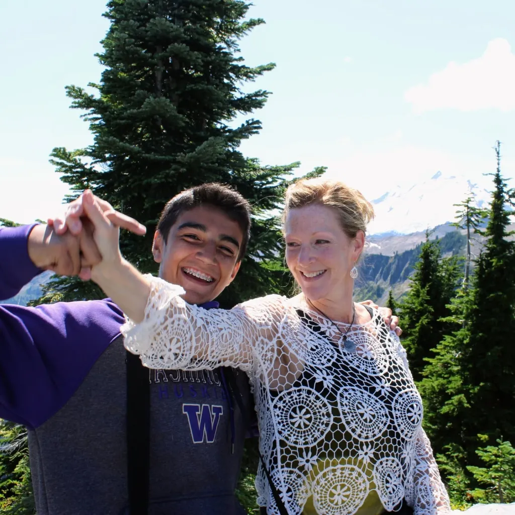 Jolayne Houtz and her son Sam outdoors in a mountainous landscape.
