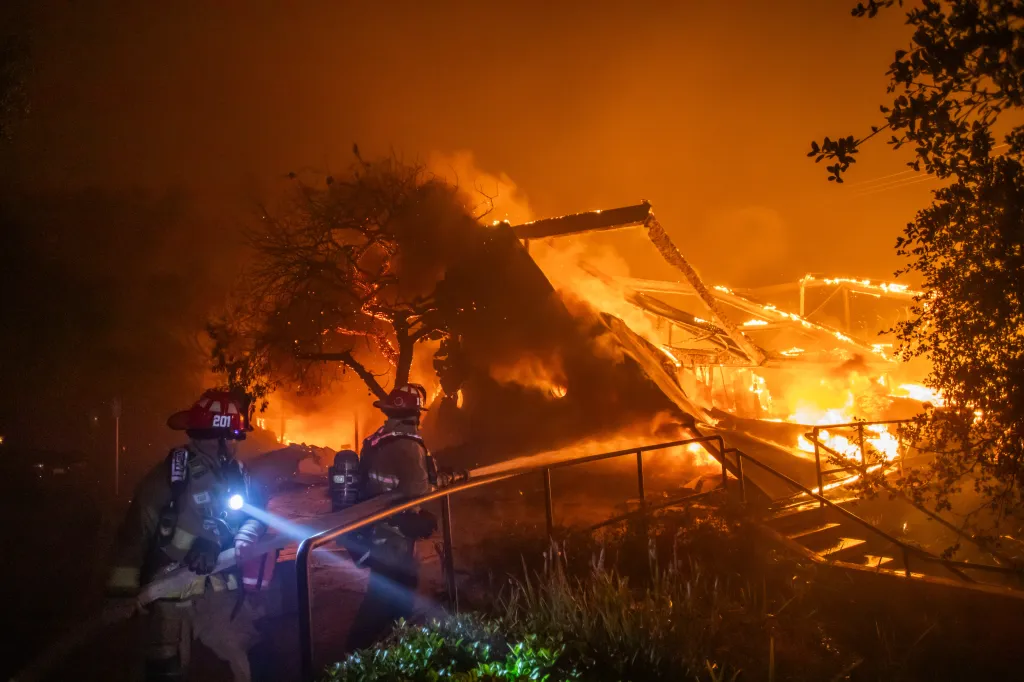 Firefighters battle flames from the Palisades Fire burning Theatre Palisades in the Pacific Palisades neighborhood of Los Angeles.