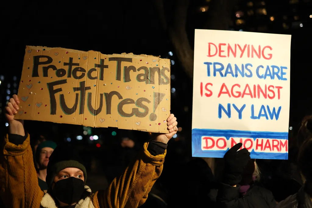 People hold signs reading 