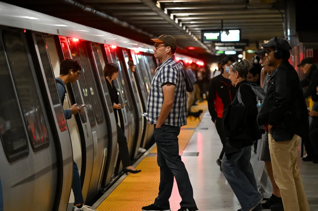 Commuters stand stranded on a platform near a Bay Area Rapid Transit (BART) train during a service outage in San Francisco.