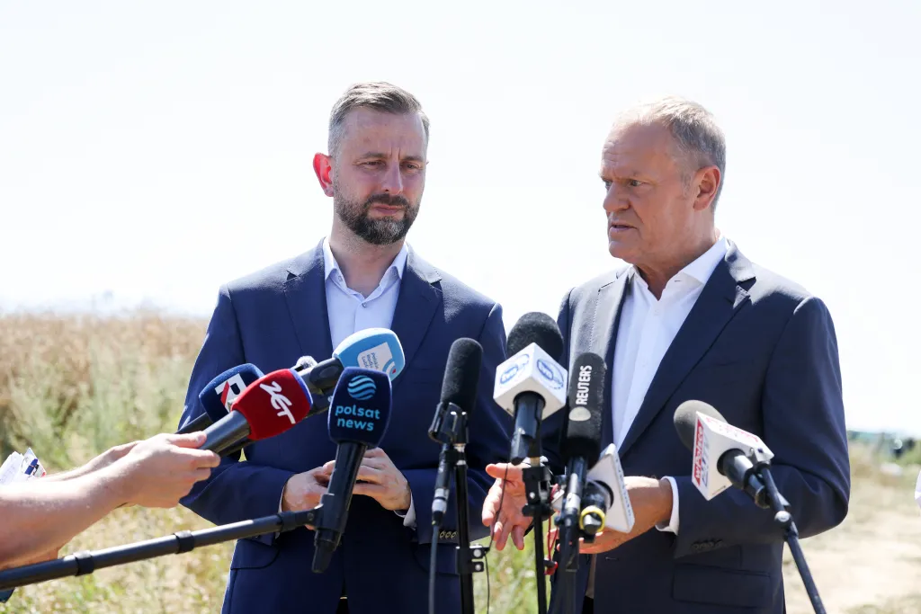 Polish Prime Minister Donald Tusk speaks to the press, while with Defence Minister Wladyslaw Kosiniak-Kamysz, near a crater in a field left by an unidentified object that appears to be a Russian missile, Polish Prime Minister Donald Tusk said on Thursday, near the village of Tarnawa-Kolonia in Lublin province, Poland, July 30, 2026. REUTERS/Kuba Stezycki
