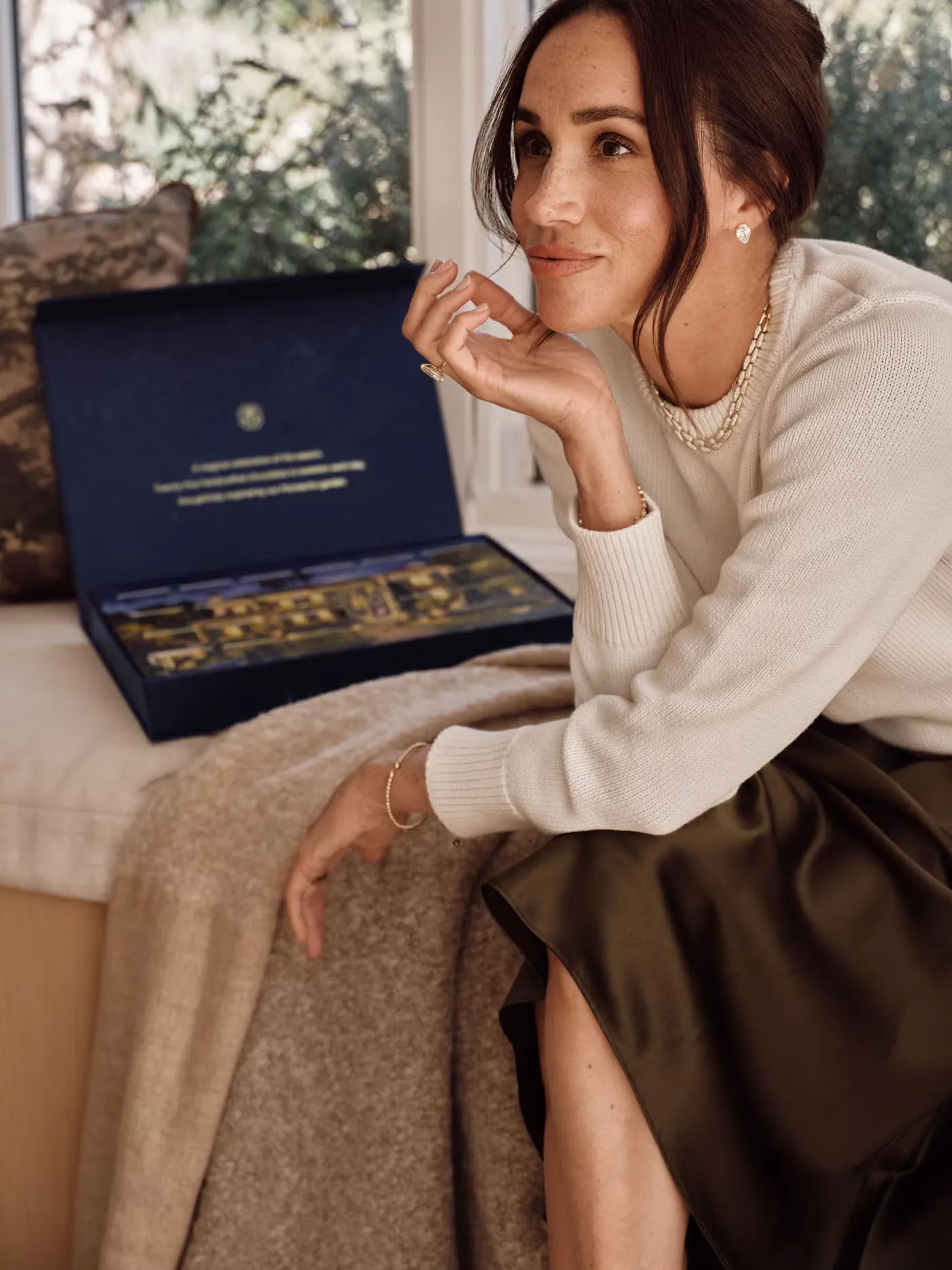 Meghan Markle sitting next to a custom advent calendar collaboration with Comparts.