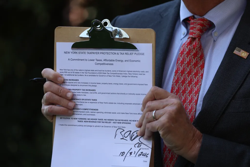 Nassau County Executive and candidate for New York State Governor Bruce Blakeman holding a signed taxpayer protection pledge.