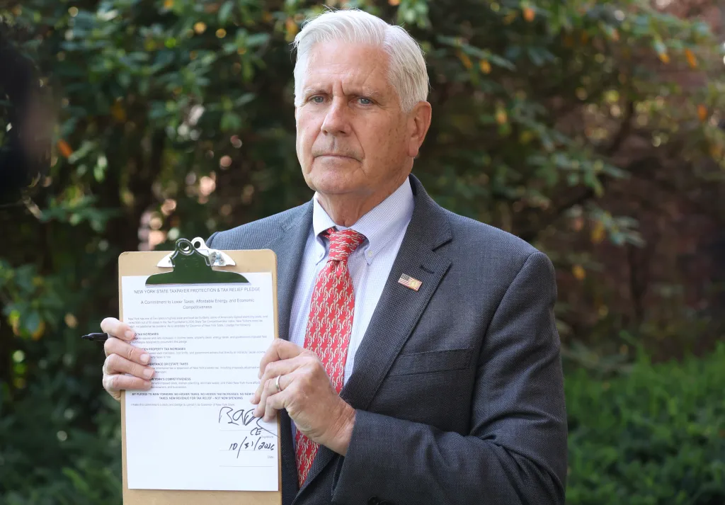Nassau County Executive Bruce Blakeman holds a signed pledge not to raise taxes.