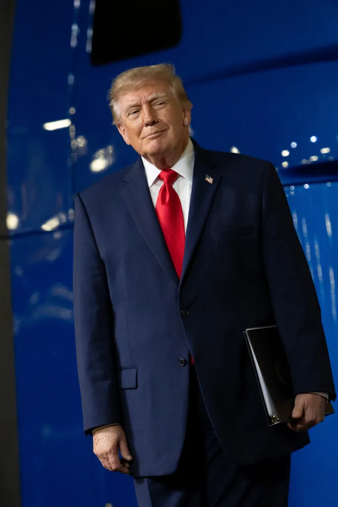 U.S. President Donald Trump stands on stage before delivering remarks at the Peterbilt Motors manufacturing plant in Denton, Texas.