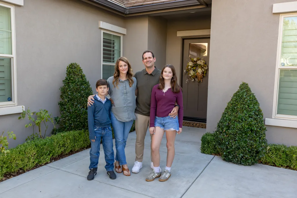 Justin and Lynne Derby stand outside their rented home in Fresno, California, with their children, Tyler and Allison.