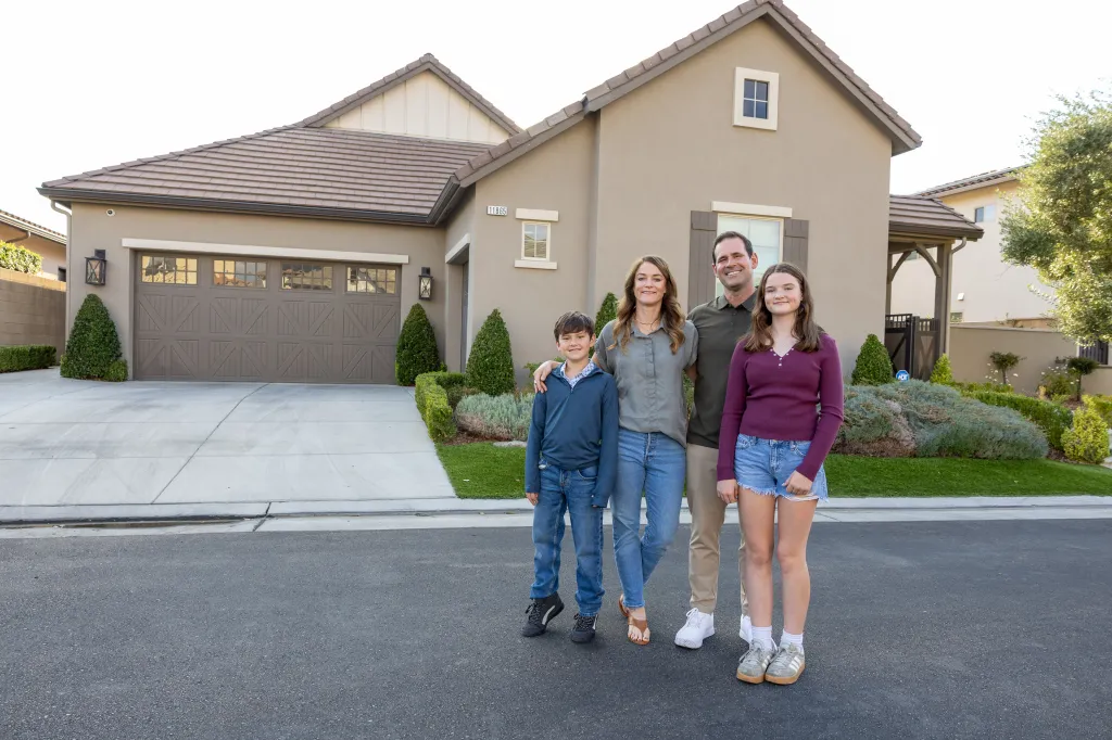 Justin and Lynne Derby stand with their children, Tyler and Allison, outside their rented home in Fresno, California.