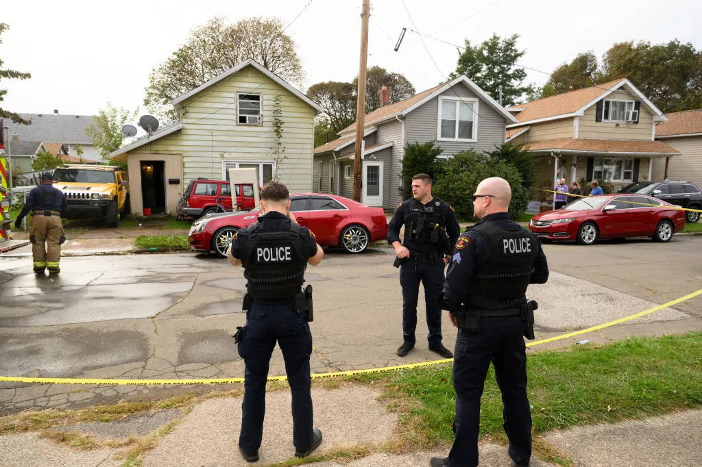 Police officers stand outside a home at on Perry Street where nine family members were killed on Oct. 10, 2026, in Erie, Pa.
