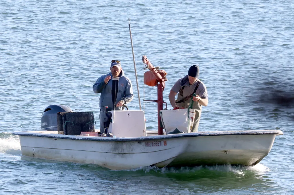 Graham Platner smokes on his Carolina Skiff boat after oyster fishing in Sullivan, Maine.
