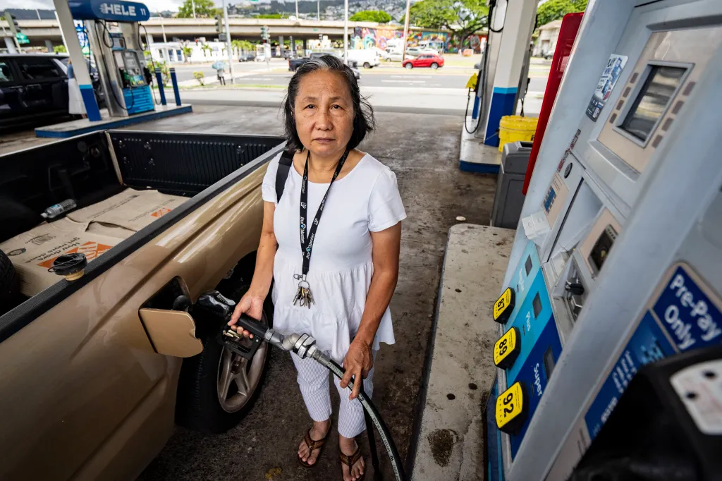 Amalia Habon pumps gas into a pickup truck at a Hele gas station in Honolulu, Hawaii.