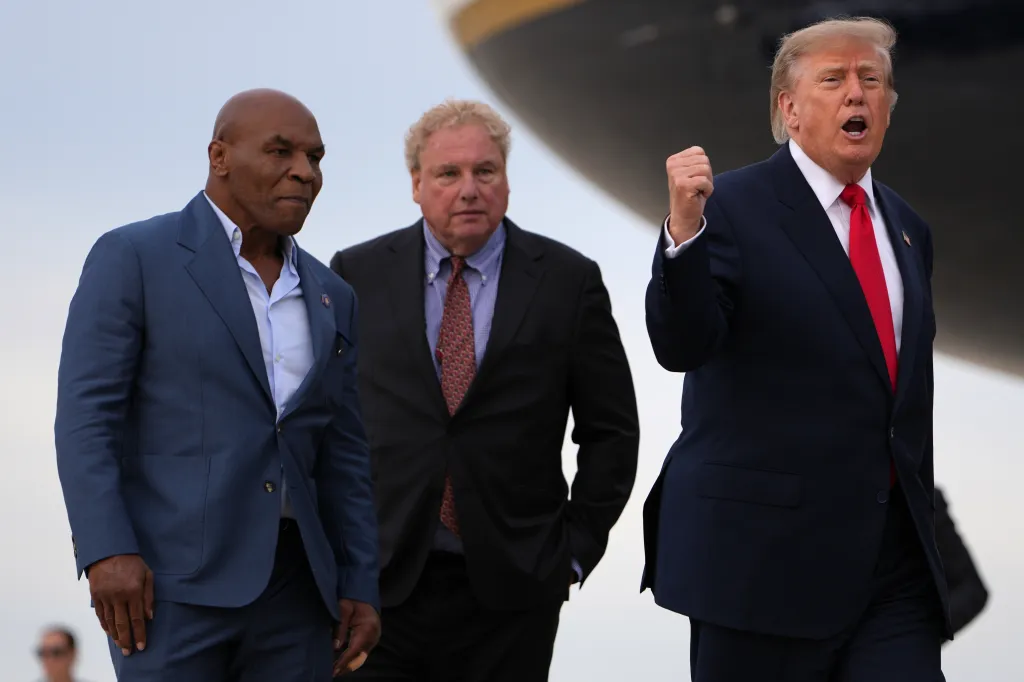 President Donald Trump walks with Mike Tyson and Randy Levine at Joint Base Andrews.