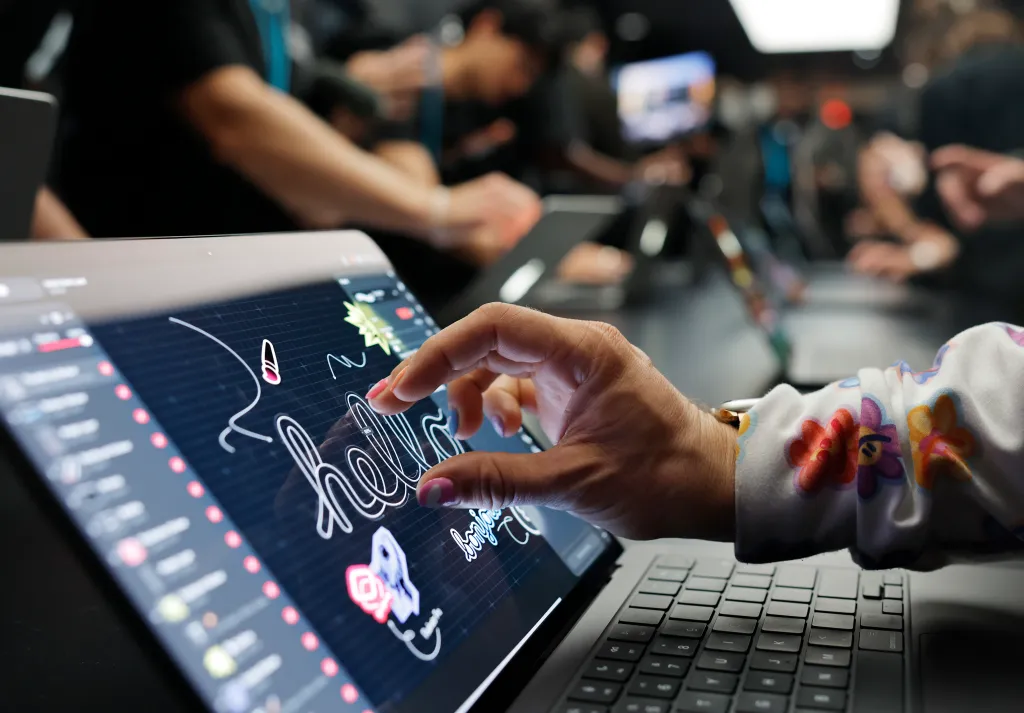 An attendee tries out the new touchscreen MacBook Pro at the Apple event in Los Angeles.