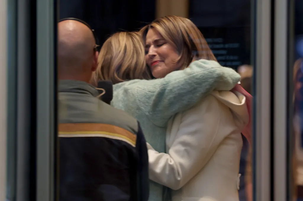 Savannah Guthrie is embraced by a colleague before stepping onto the 