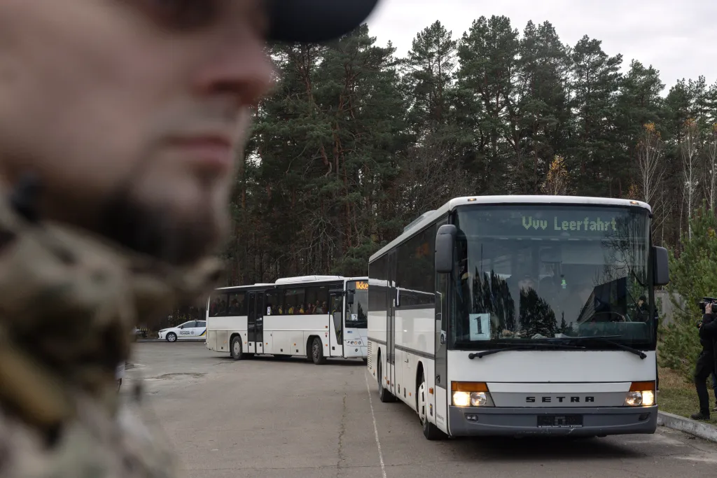 A Ukrainian serviceman watches as buses carrying evacuees from Oleshky arrive near Chernihiv.