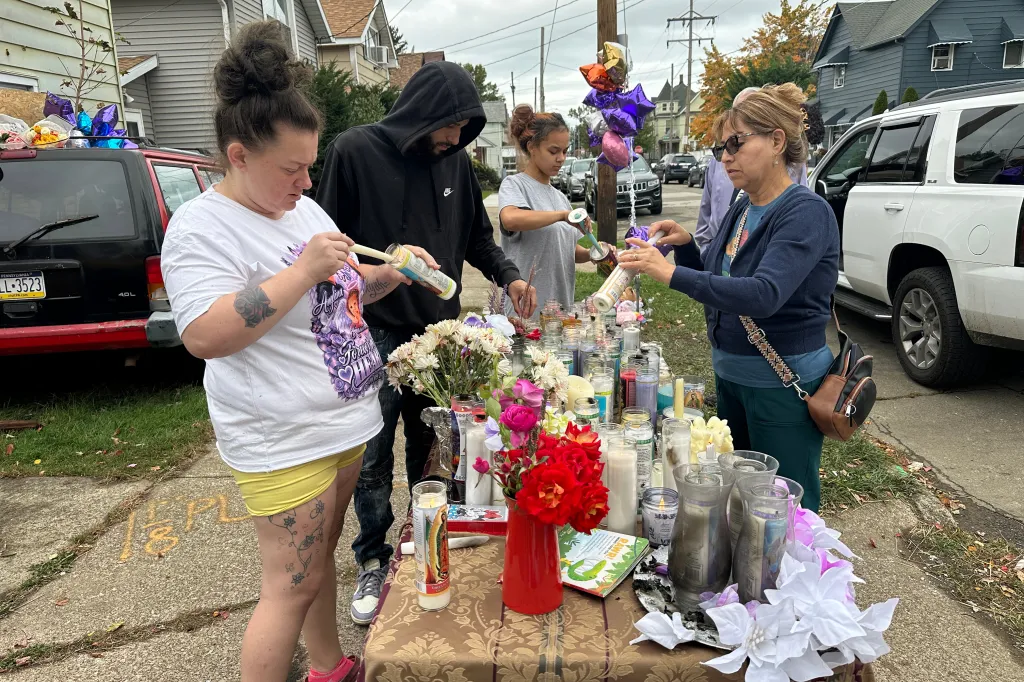 People gather at a memorial outside a home in Erie, Pa., Sunday, Oct. 11, 2026, where authorities say a gunman killed several people before killing himself on Oct. 9.