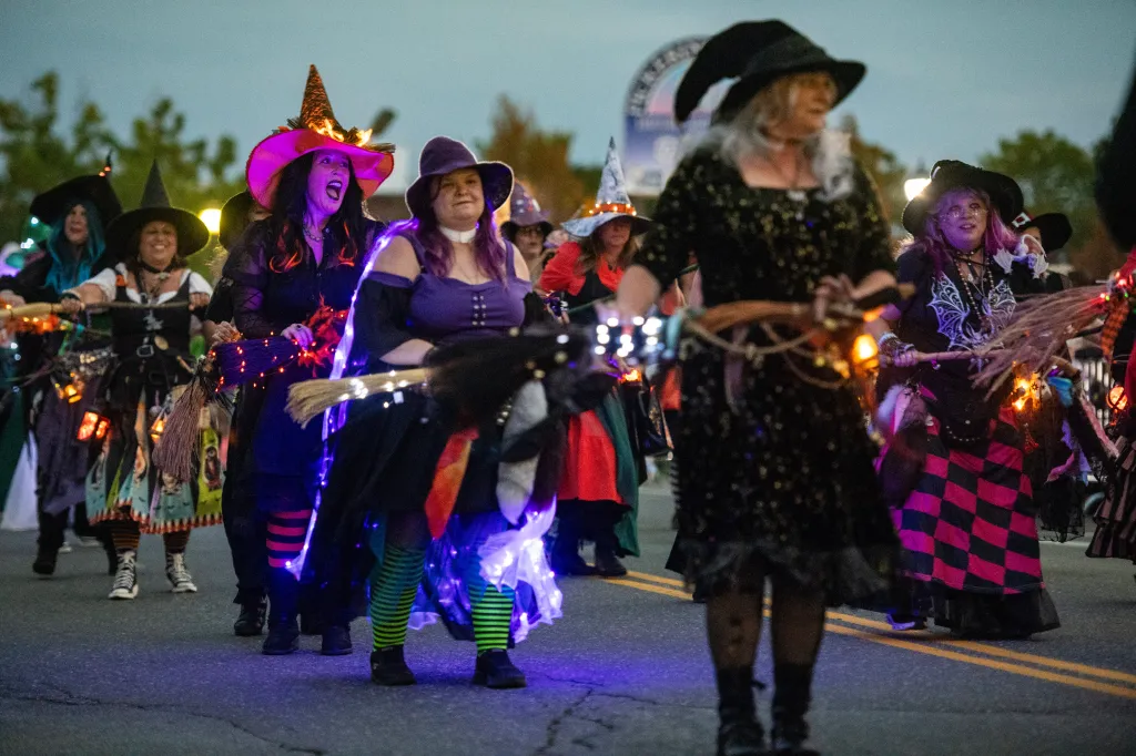 Revelers wear witch costumes and march in the Salem Haunted Happenings Grand Parade.