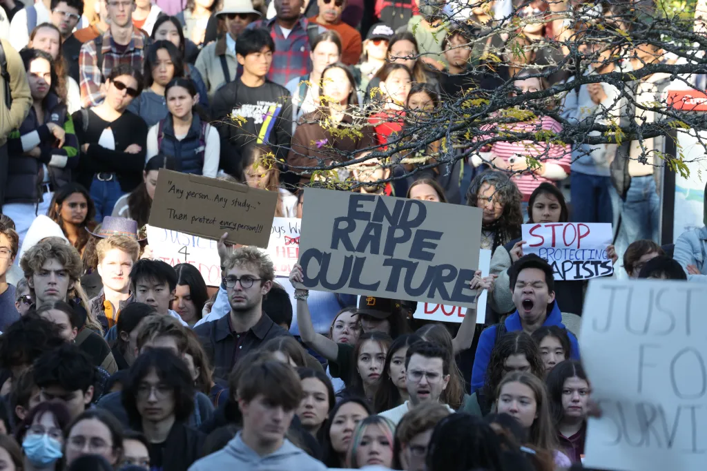 Protesters gather on Cornell's campus holding signs that read