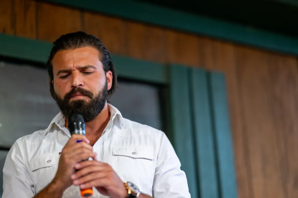 Republican congressional candidate Brandon Herrera speaks into a microphone during a campaign rally.