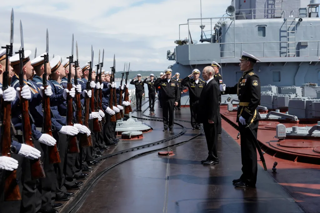 Russian President Vladimir Putin is welcomed on board the missile cruiser Varyag.