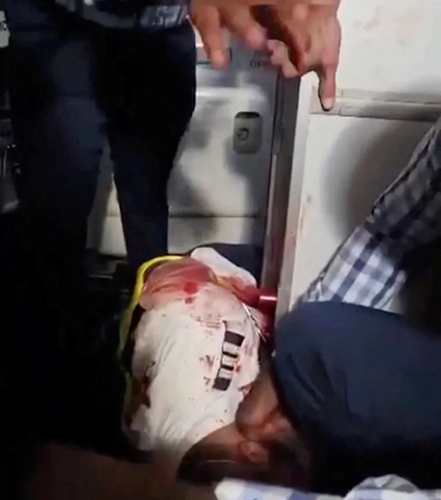 Passengers gather around an injured man aboard a flydubai plane.