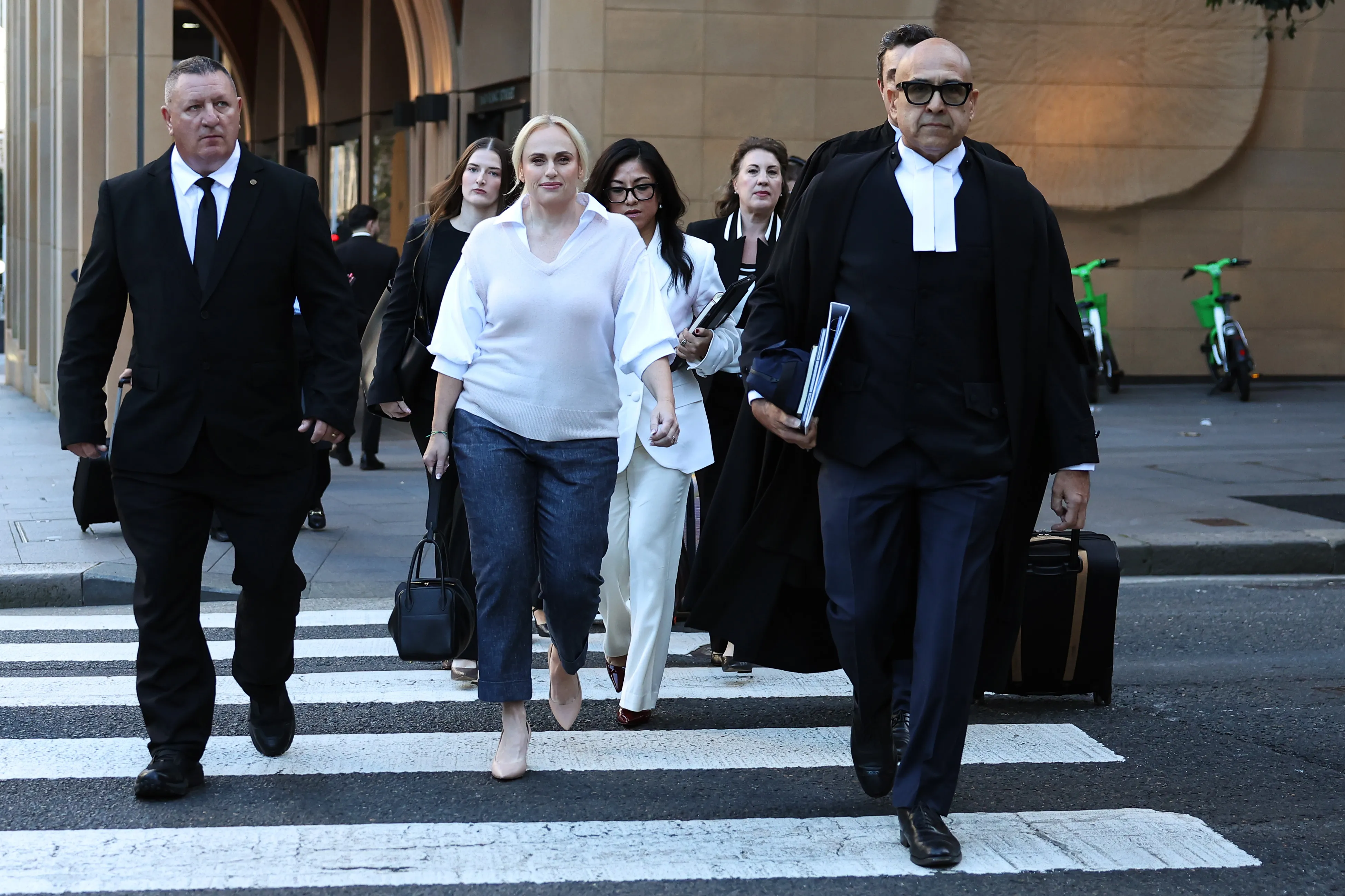 Rebel Wilson and her legal team walk across a pedestrian crossing outside the Federal Court in Sydney.