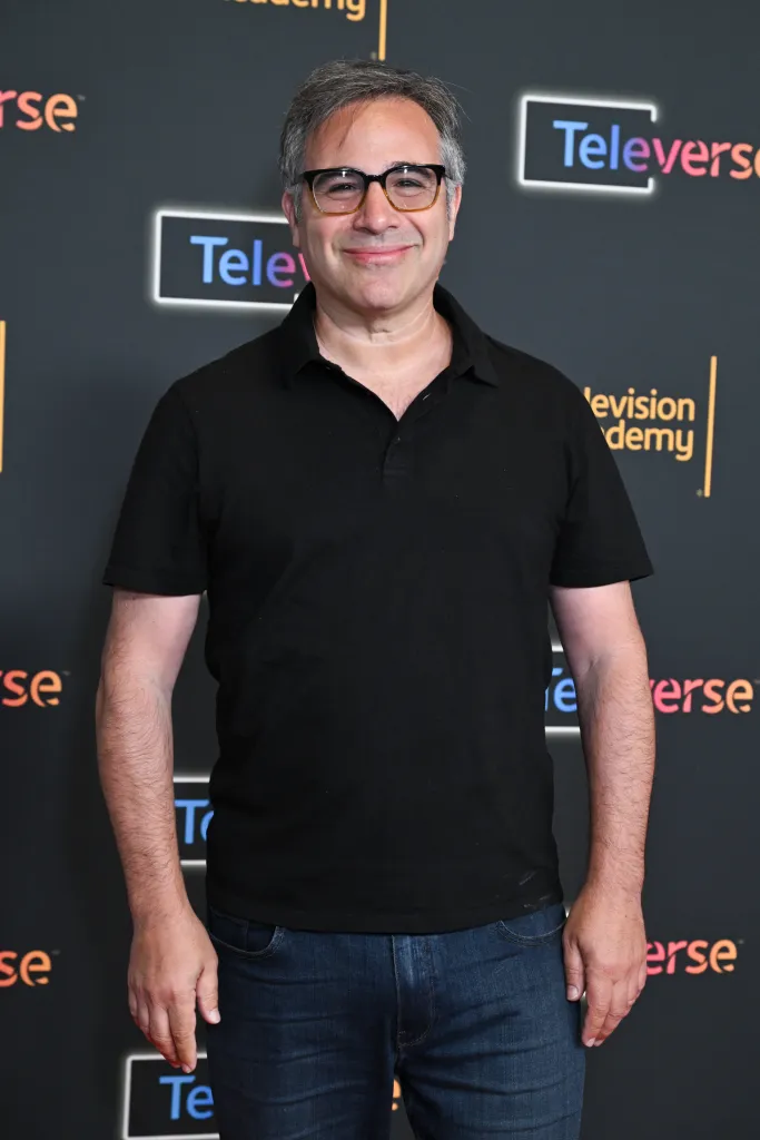 Brad Caleb Kane stands in front of a Televerse Festival backdrop.