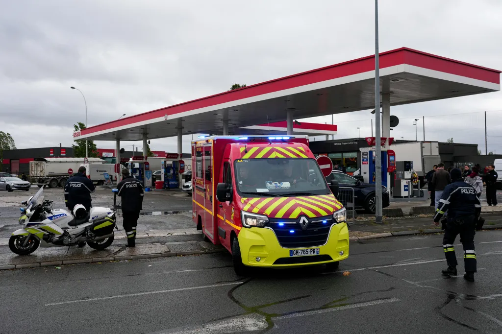Emergency services and police officers at a petrol station following a shooting incident.