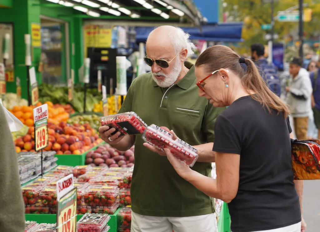 Customers check fruit at a grocery store in New York.