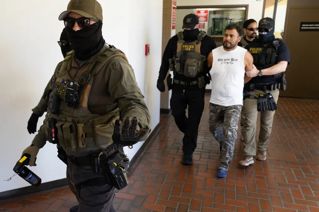 Immigration and Customs Enforcement agents lead a detainee out of the Ventura County Government Center.
