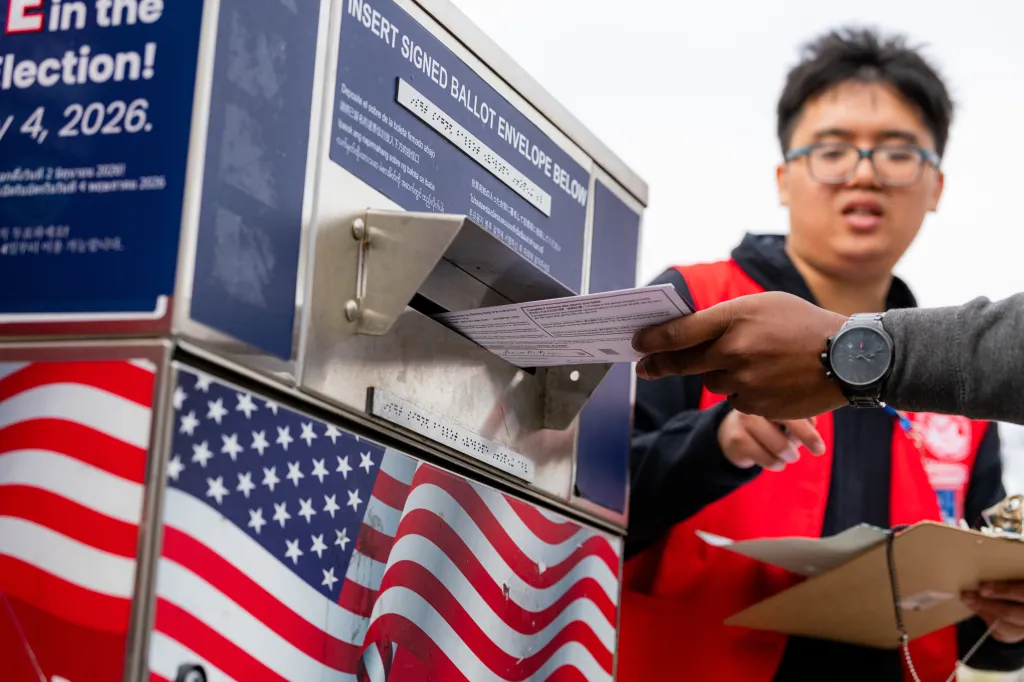 A voter drops a ballot into an official drop box during a primary election in San Francisco.