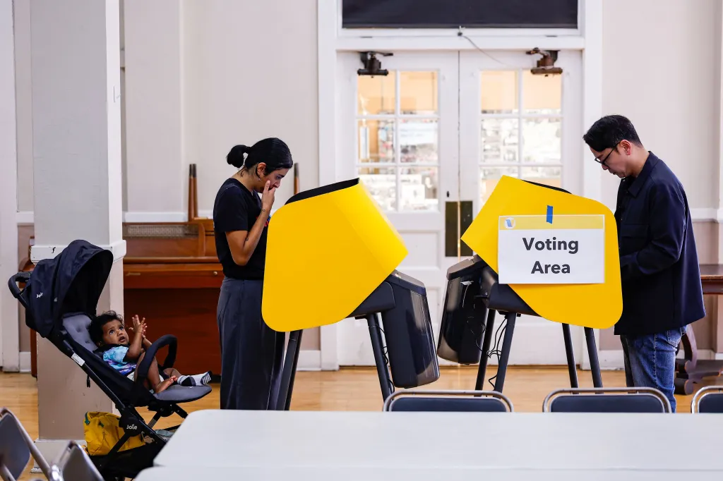 People casting ballots in voting booths during early voting in Los Angeles.