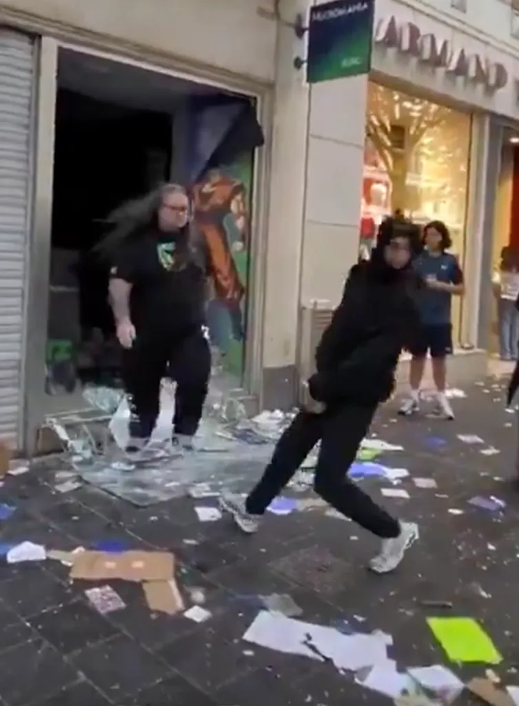 A store clerk defending his storefront from a looter amid scattered debris.