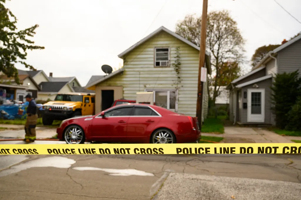 Yellow police tape blocks off a street in front of a house in Erie, Pennsylvania, following a shooting.