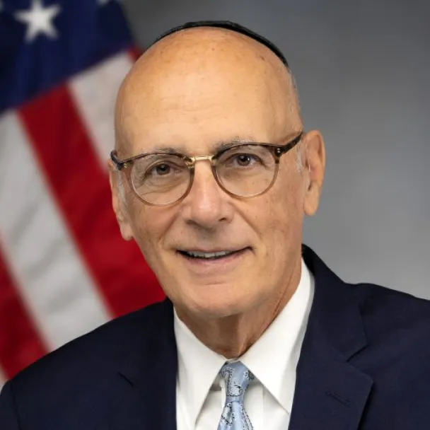 New York State Senator Sam Sutton in front of an American flag.