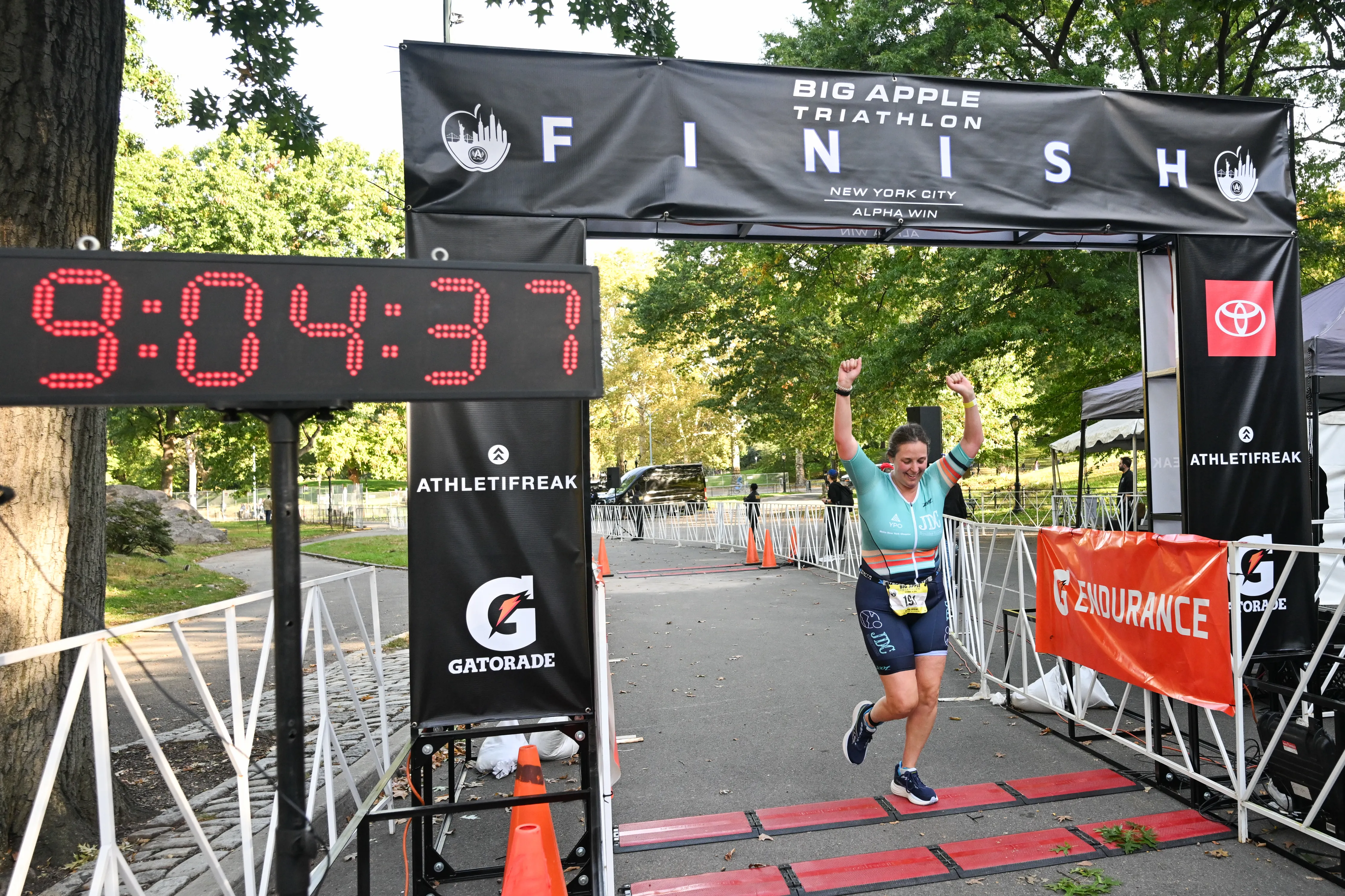 A runner celebrates while crossing the finish line of the Big Apple Triathlon in New York City.